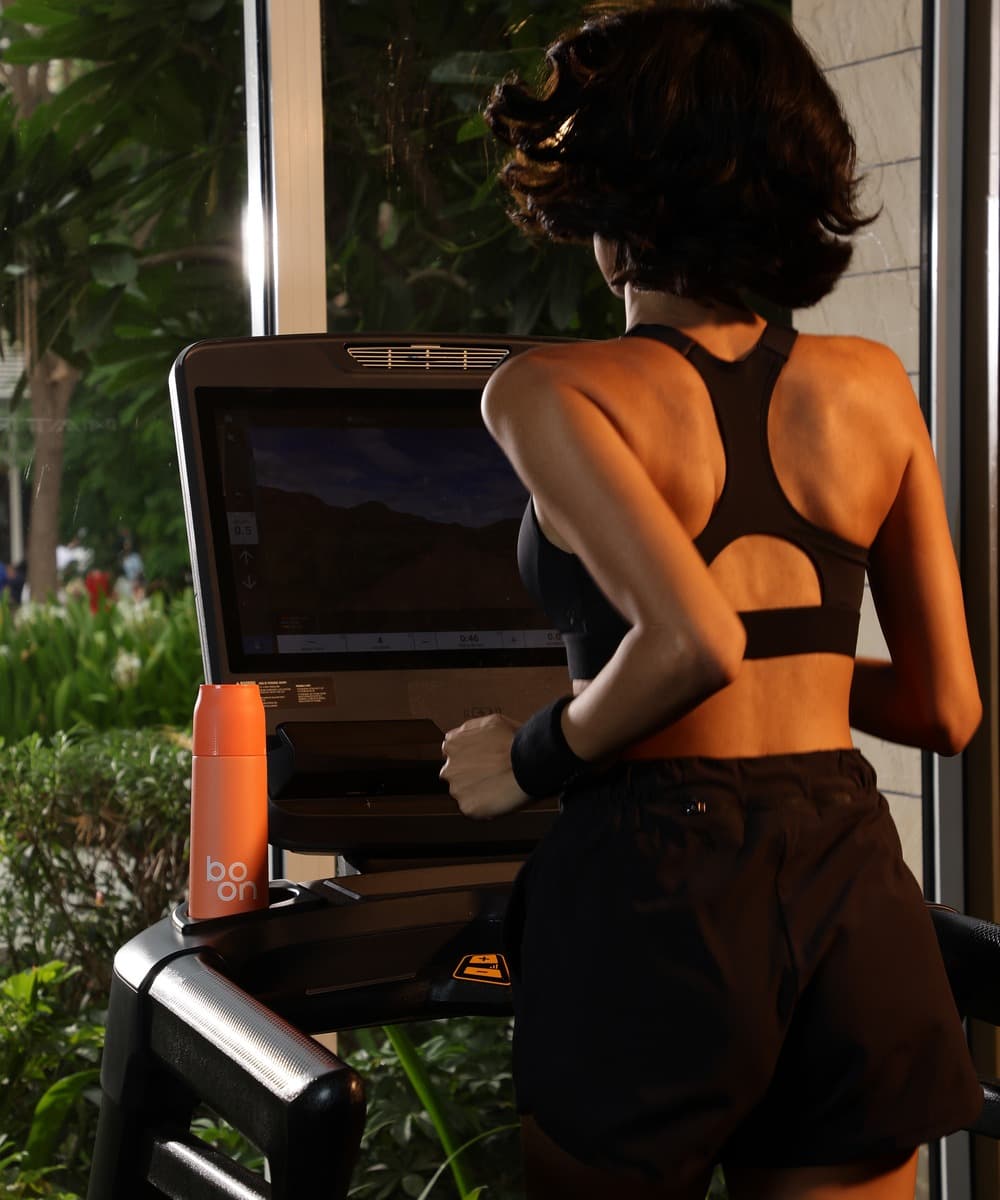 Runner refilling a Boon bottle at the gym