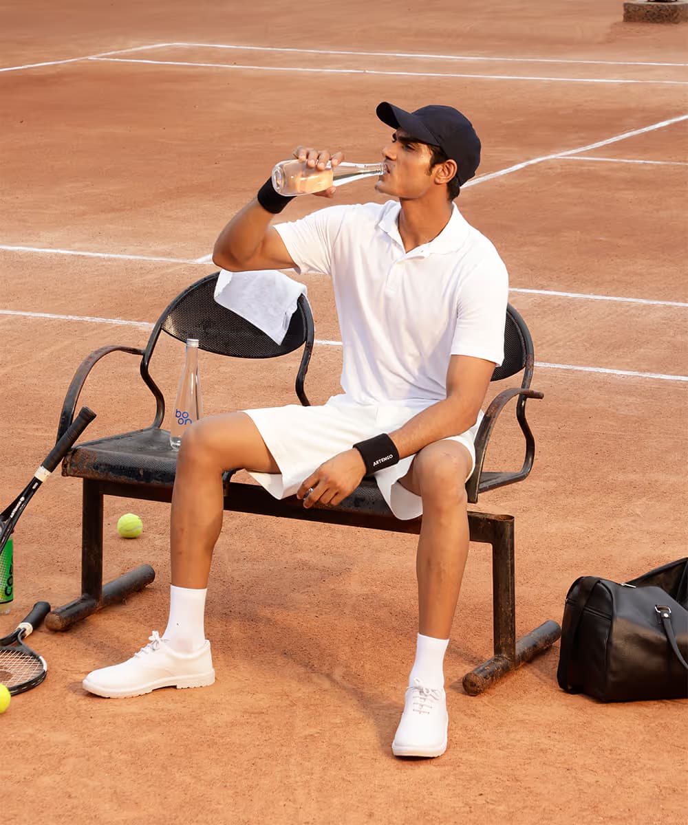 Tennis player drinking Boon water courtside