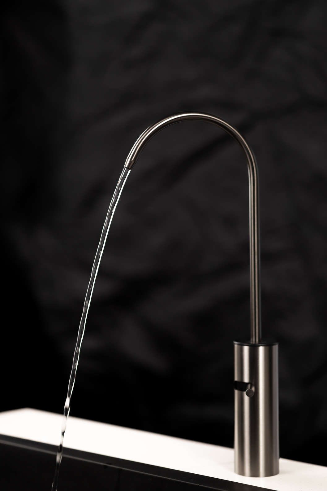 Boon Tap running a steady stream of filtered water against a dark kitchen backdrop.