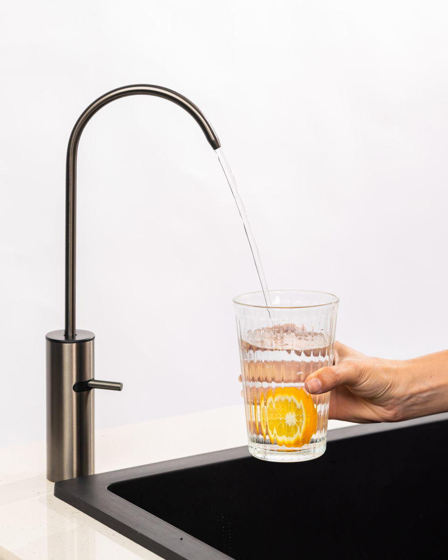 A glass of water with lime beside Boon Tap.